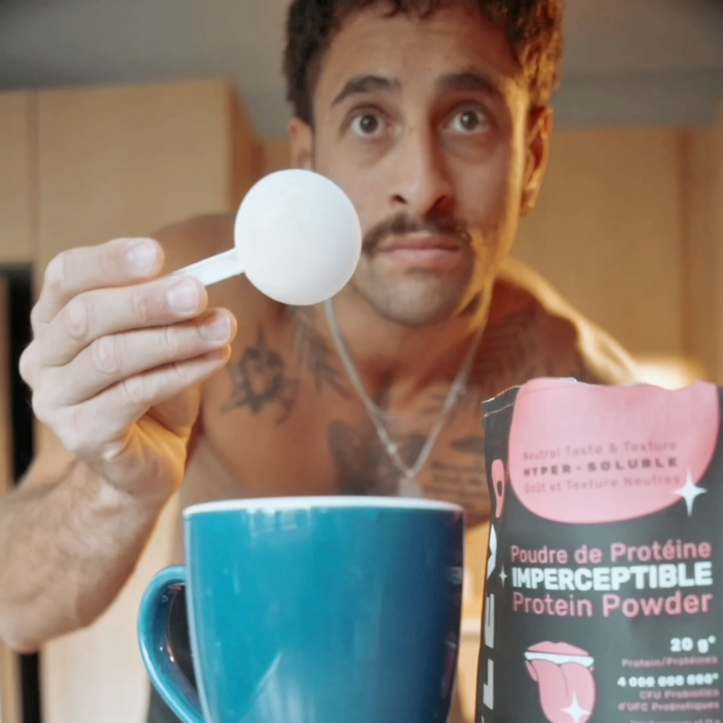 Man holding ELEVO Nutrition protein powder scoop with mug