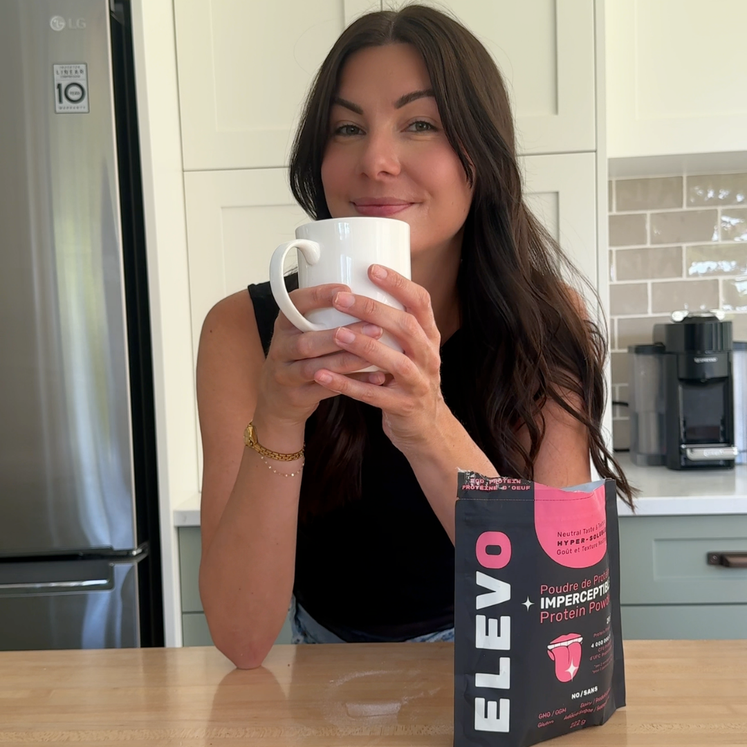 Woman holding a mug in a kitchen with an ELEVO Nutrition protein powder package on the counter.
